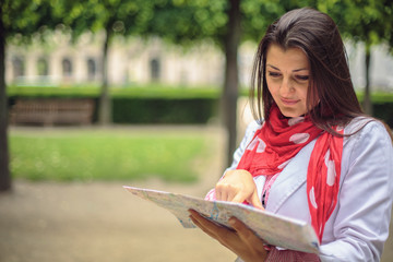 Young woman looking on the map at the city park Paris, France
