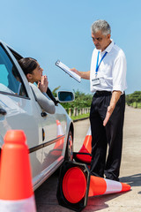 female learner driver apologising to angry instructor