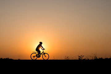 Obraz premium Silhouette of cyclist motion on sunset background
