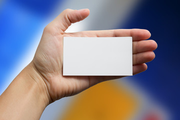 Fototapeta premium Hand holding white business card on blurred background