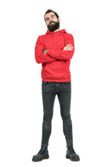 Proud confident bearded man in red hoodie with crossed arms looking at camera. Full body length portrait isolated over white studio background. 