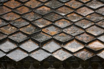 Diamond shaped roof tiles after a heavy rain shower has made them wet. 