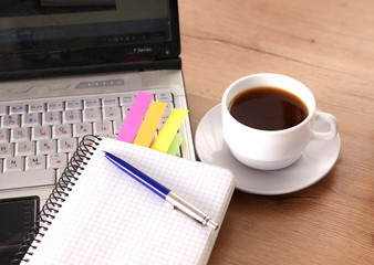 Office table with blank notepad and laptop 