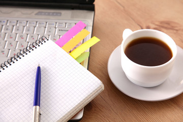 Office table with blank notepad and laptop 