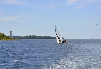 Poster Zeilen small sailboat sailing along Georges Island near the light house,  Halifax, Nova Scotia Canada  © skyf
