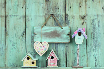 Blank sign with heart by colorful birdhouses