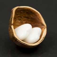 Hazelnut shell with heart shaped agate on black background