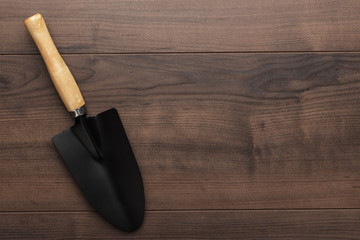 black gardening shovel on the wooden table with copy space