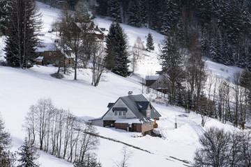 Frosty snowy country with houses in a sunny winter day