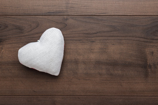 knitted plush heart shape on the wooden table