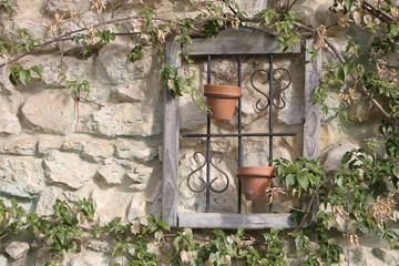 romantic window with crock pots on the stone wall