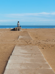 Solitary figure on a deserted beach.