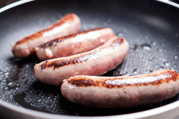 Cooking sausages in the dripping pan with oil