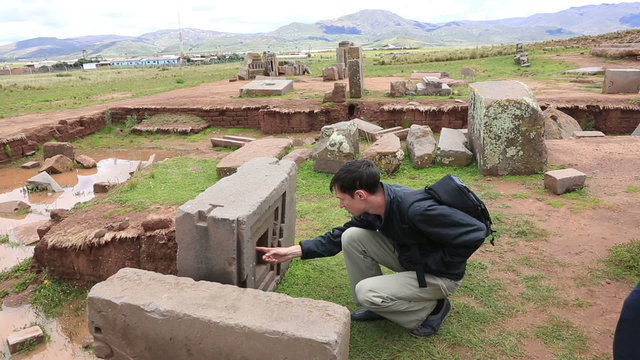 Man is looking at megalithic stones in the complex Puma Punku near Tiwanaku, Bolivia