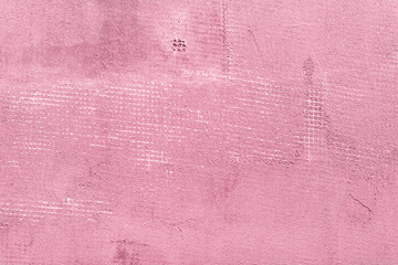 Splitted and cracked concrete wall with net and holes, textured cement background. Pink and rosy vintage colors