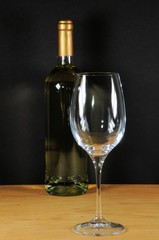 White wine bottle with glass on the wooden table