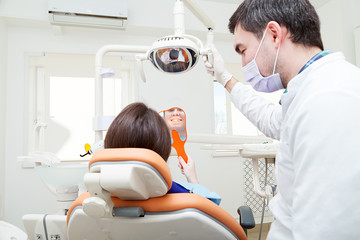 Happy young female patient visiting dentist for teeth whitening