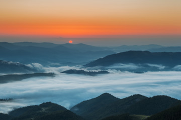 Naklejka na ściany i meble Carpathian Mountains. Mountains covered in mist at sunrise