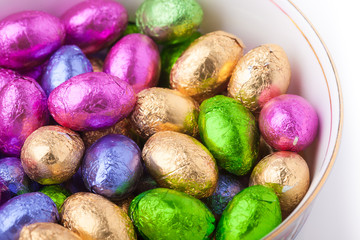 Chocolate eggs in foil in a china bowl