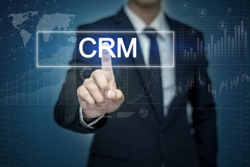 Businessman hand touching CRM button on virtual screen