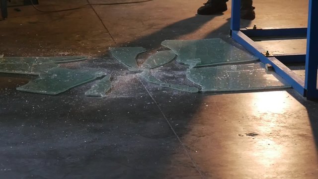 Crackled Sheet of Glass is Falling Down And Breaking, Crumbling, Workers Removes Glass Sheet from the Floor, Testing of Bulletproof Glass