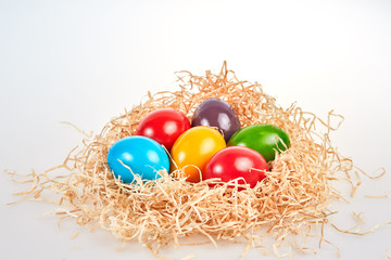 Isolated easter nest of straw with six eggs