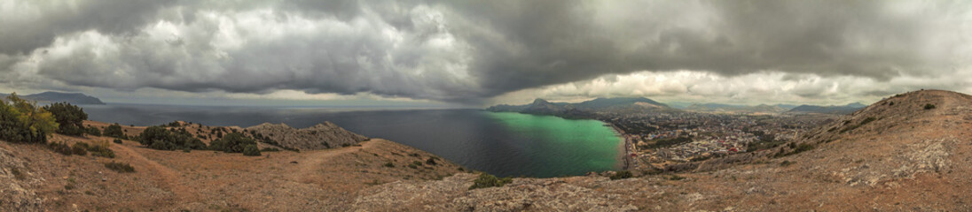 panorama, horizontal view of Crimean mountains with rocky coastline, Black sea before the rain, storm