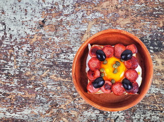 breakfast in a clay pot on aged table