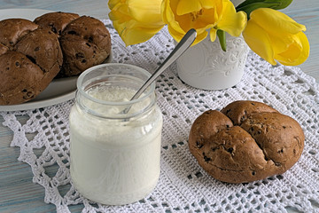 Breakfast.    Yogurt in a jar and bread rolls on a white knitted napkin.