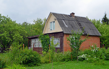Fototapeta na wymiar Старый загородный дом, выставленный на продажу, на заросшем приусадебном участке