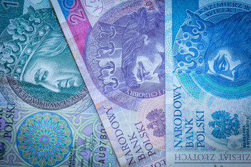 Three Polish zloty banknotes: green, pink and blue