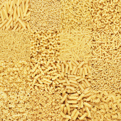 big collection of different dry uncooked pasta on the table texture background