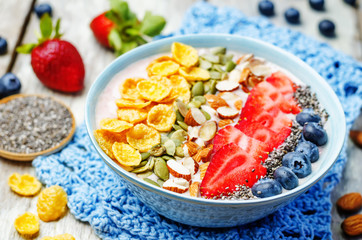 healthy strawberry smoothie bowl with fruits, cereals, seeds and
