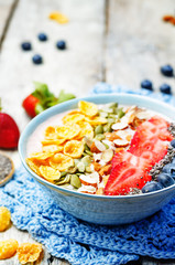 healthy strawberry smoothie bowl with fruits, cereals, seeds and