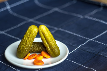 Pickled cucumbers and carrots cut. Looks delicious. Dietary food. Blue background.