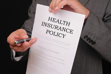 Health insurance concept. Man offering a pen to sign policy close up.