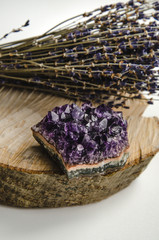 Raw amethyst rock with bunch of aromatic lavender flowers on natural wood rustic esoteric 