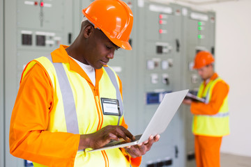 black technical worker using laptop