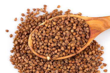 Uncooked buckwheat on wooden spoon