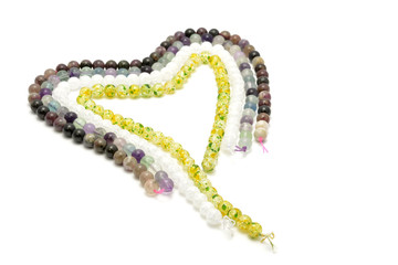 Strings of gems for making jewellery on white background