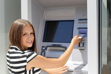 woman inserting credit card in to  ATM
