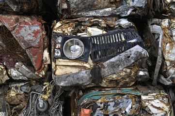 Fototapeta premium A pile of compressed cars in blocks for processing