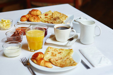 Breakfast withorange juice, pastry, pancakes and coffee