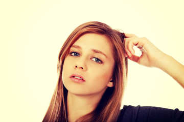 Fototapeta premium Pensive teenage woman scratching her head