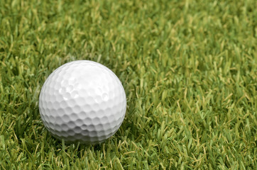 Golf ball on course with green grass.