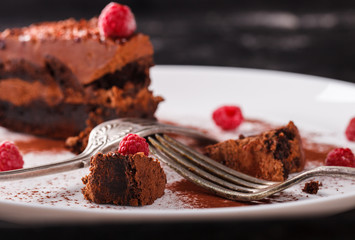 Piece of chocolate cake with raspberry on a dark background.selective focus.