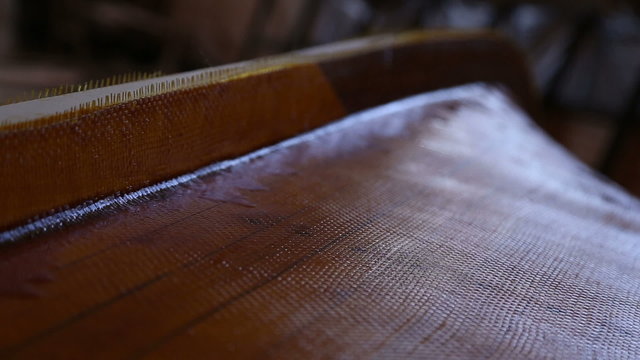 Construction of a boats at the shipyard, the frames has been covered with wooden planks, the seams plastered with resin, the boat is covered with fiberglass
