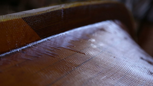 Construction of a boats at the shipyard, the frames has been covered with wooden planks, the seams plastered with resin, the boat is covered with fiberglass
