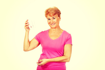 Smiling senior woman holding a tooth model