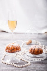 Fruit muffins with dried fruit and candied fruit decoration with pearls and a glass of champagne.selective focus.